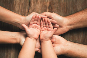 Tennessee Child Support Law - Adult hands holding a child's hands, showing support and care.